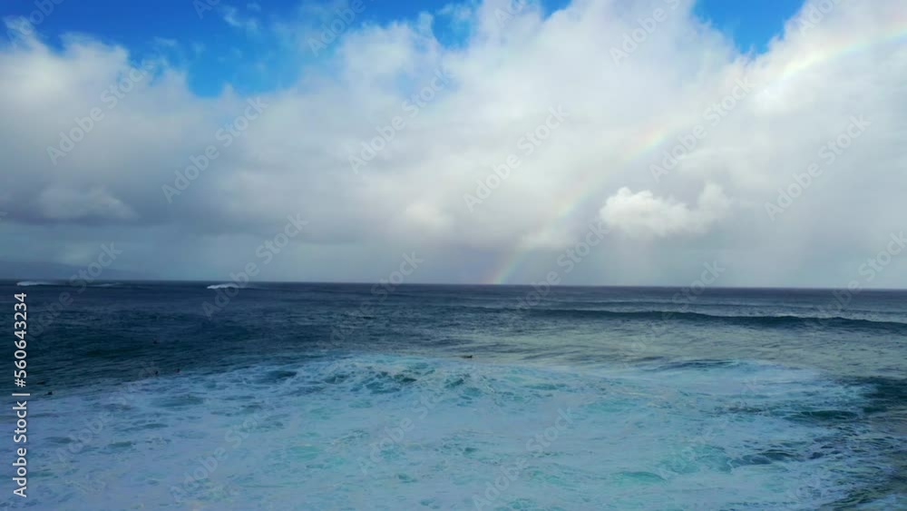Aerial Scenic Shot Of Rainbow In Fluffy Clouds, Drone Flying Forward Over Wavy Ocean - Waikiki, Hawaii Aerial Scenic Shot Of Rainbow In Fluffy Clouds, Drone Flying Forward Over Wavy Ocean - Waikiki, Hawaii