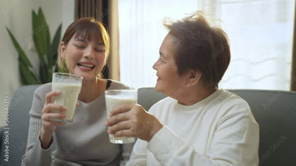 Asian people drinking soy milk together at home. They feeling fresh and happy when drink soy milk in living room.