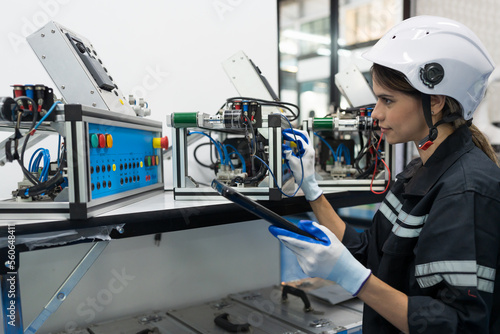 Female engineer control autonomous mobile robot or AMR in the manufacturing automation and robotics academy room. Woman engineer training or maintenance AI robot