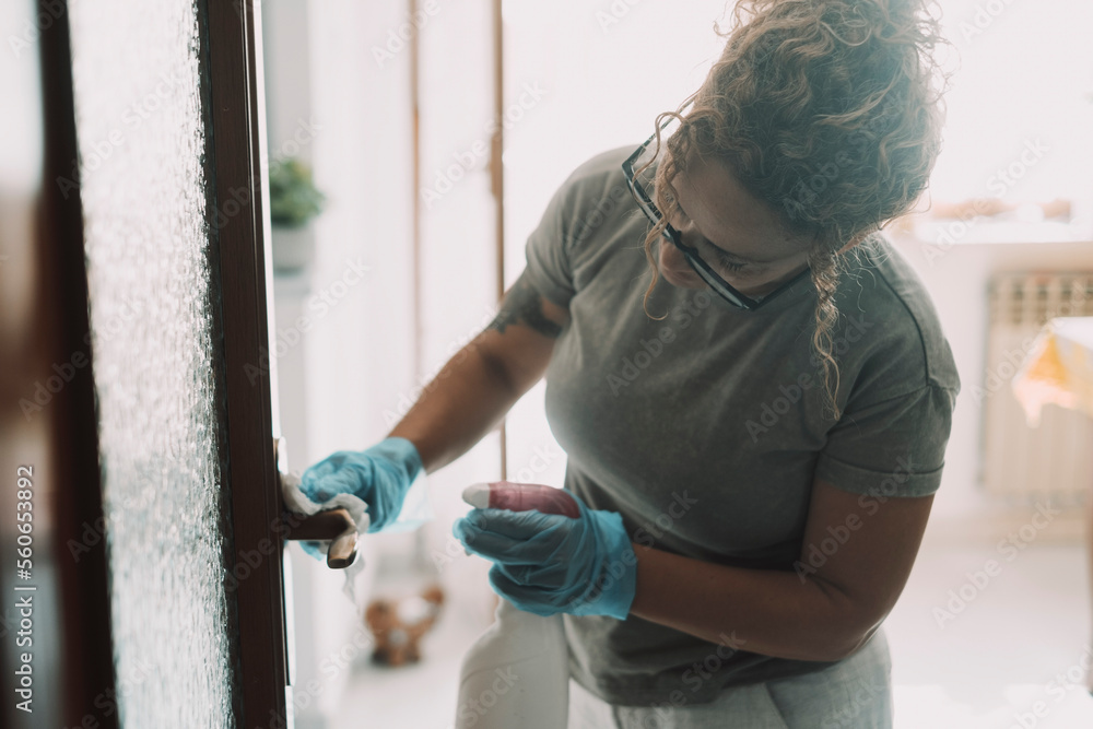 Domestic work at home. One woman cleaning door in apartment with spray and gloves. Housewife job. Hygiene and sanitize life place. Housemaid working and clean house surfaces. Concept of healthy Domestic work at home. One woman cleaning door in apartment with spray and gloves. Housewife job. Hygiene and sanitize life place. Housemaid working and clean house surfaces. Concept of healthy