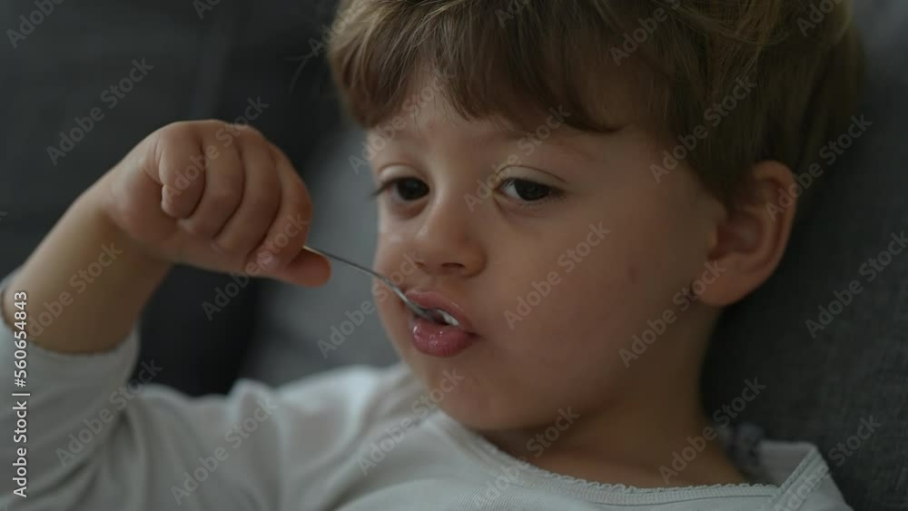 Child eating yogurt with spoon. Close up face of little boy eats nutritious breakfast food Child eating yogurt with spoon. Close up face of little boy eats nutritious breakfast food
