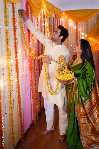 Obraz na plátně Portrait of an Indian couple decorating their house during the festival - Diwali