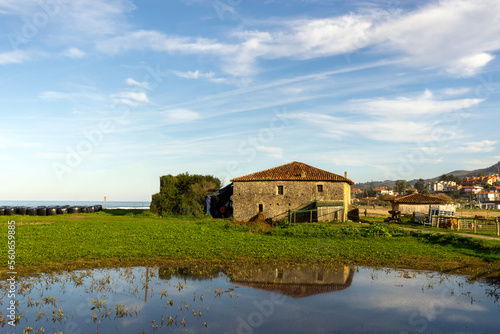Casona rural asturiana reflejada en una pequeña laguna. Justo detrás de la edificación se encuentra la playa de La Espasa. Asturias, España.