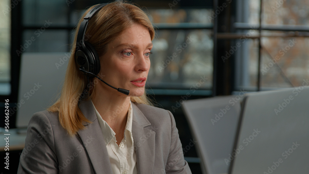 Caucasian middle-aged adult woman business female 30s businesswoman worker in office with headset using computer talking working customer support service operator helpline agent manager in headphones Caucasian middle-aged adult woman business female 30s businesswoman worker in office with headset using computer talking working customer support service operator helpline agent manager in headphones