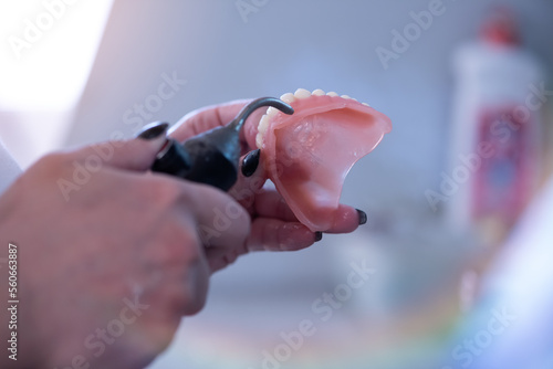 Dental technician works by brush with jaw model. Facial Dental Prosthetic