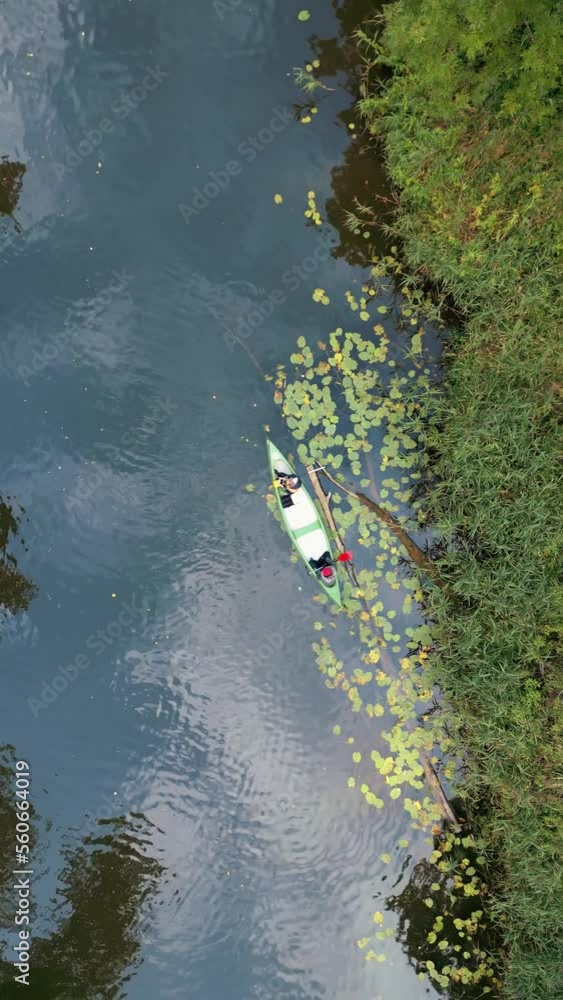 Vertical mode: view from a drone to canoe on the river in a nordic forest