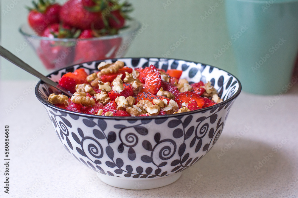 Strawberry salad with walnuts and poppy seeds in a black and white plate Strawberry salad with walnuts and poppy seeds in a black and white plate