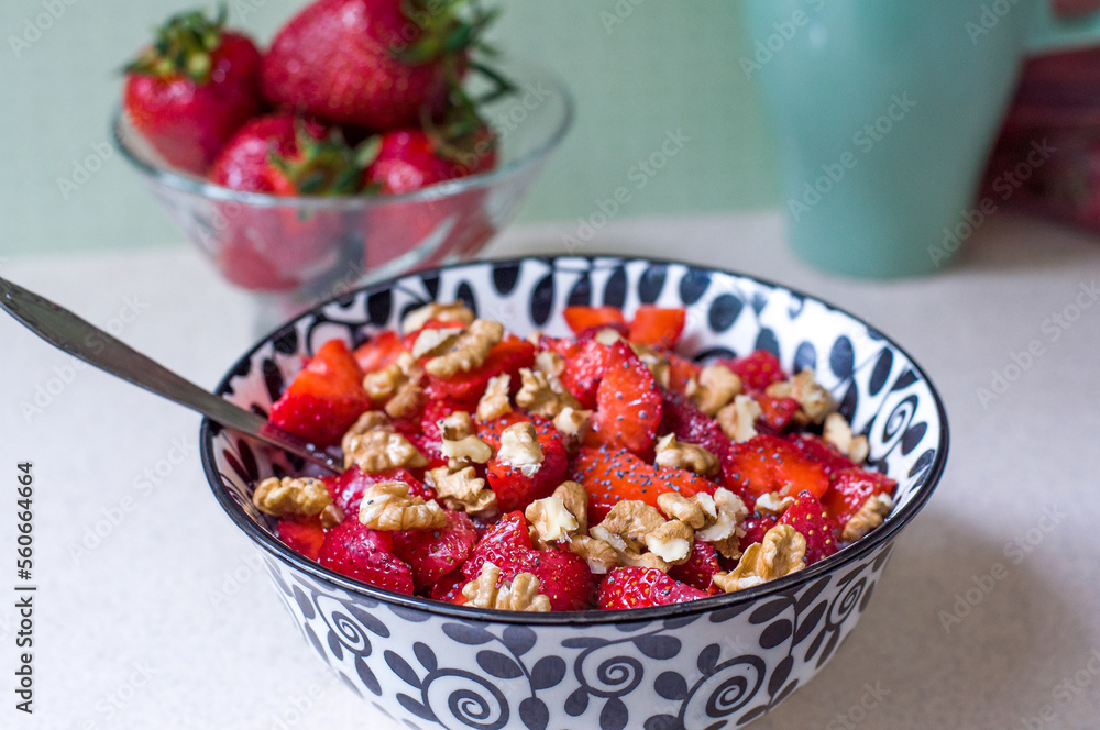 Strawberry salad with walnuts and poppy seeds in a black and white plate Strawberry salad with walnuts and poppy seeds in a black and white plate