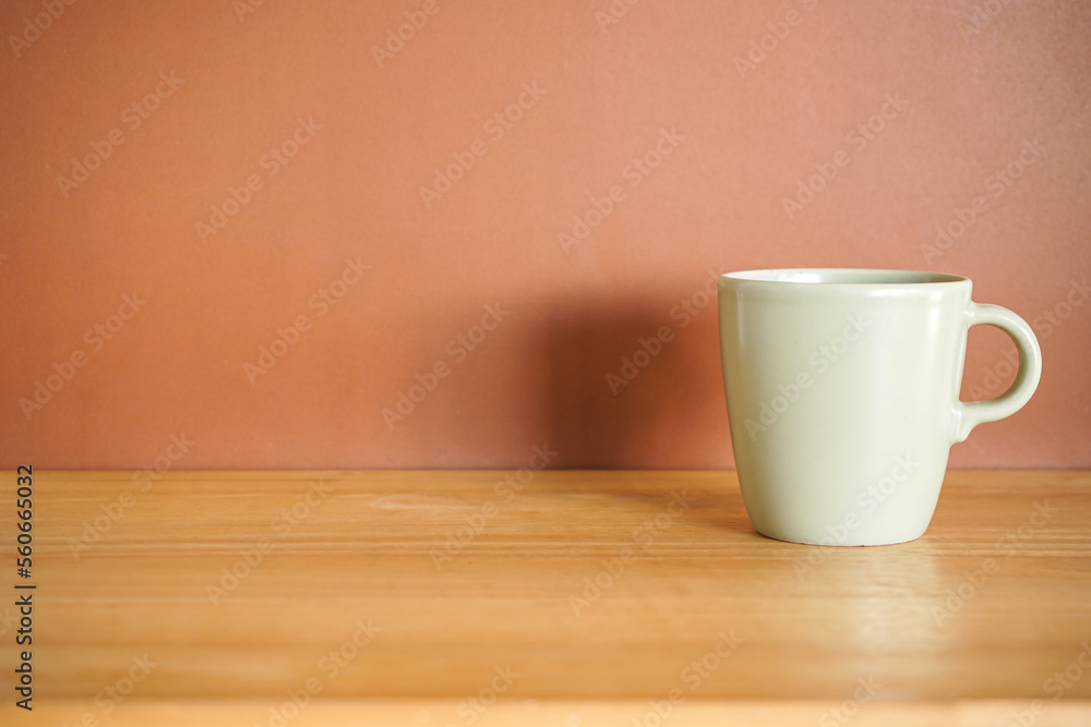 Green Ceramic coffee mug on wood table with brown background Green Ceramic coffee mug on wood table with brown background