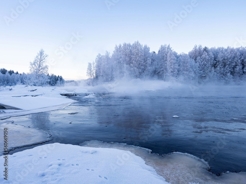 Strong frost in January on the Shuya River in the Republic of Karelia, northwestern Russia. Steam over water. The waterfall in the river is partially frozen. © Igor Podgorny