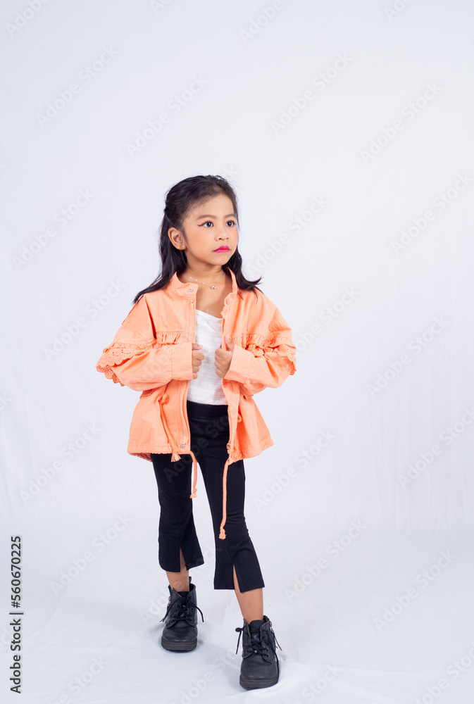 A cute asian child model posing in studio. Stylish adorable 6 years old little girl in her fashionable dress isolated on white background. A cute asian child model posing in studio. Stylish adorable 6 years old little girl in her fashionable dress isolated on white background.