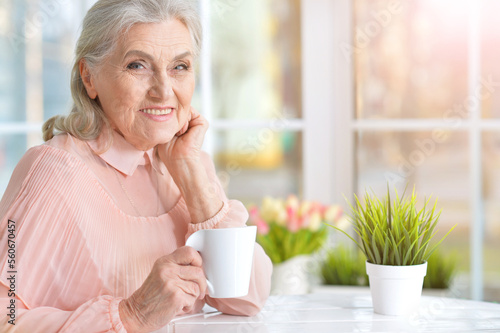 smiling senior woman drinking tea at home