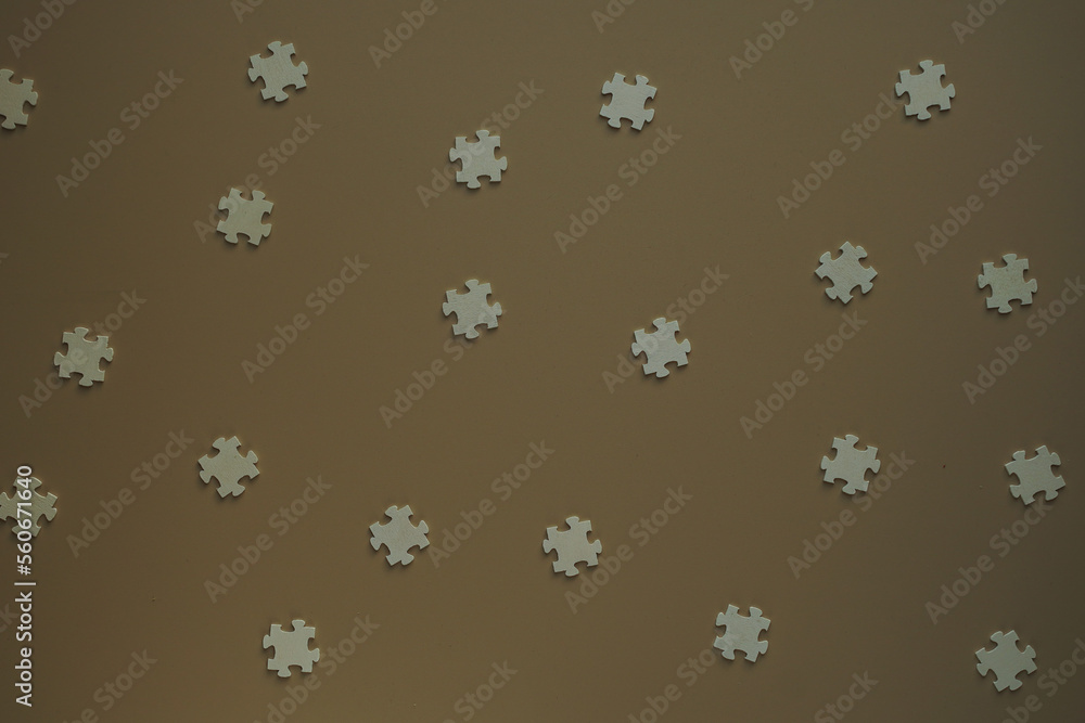 Flat blank wooden puzzles on brown background view from above. Festive background for a congratulatory inscription. New Year, Christmas, Valentine, Birthday. Blurred background