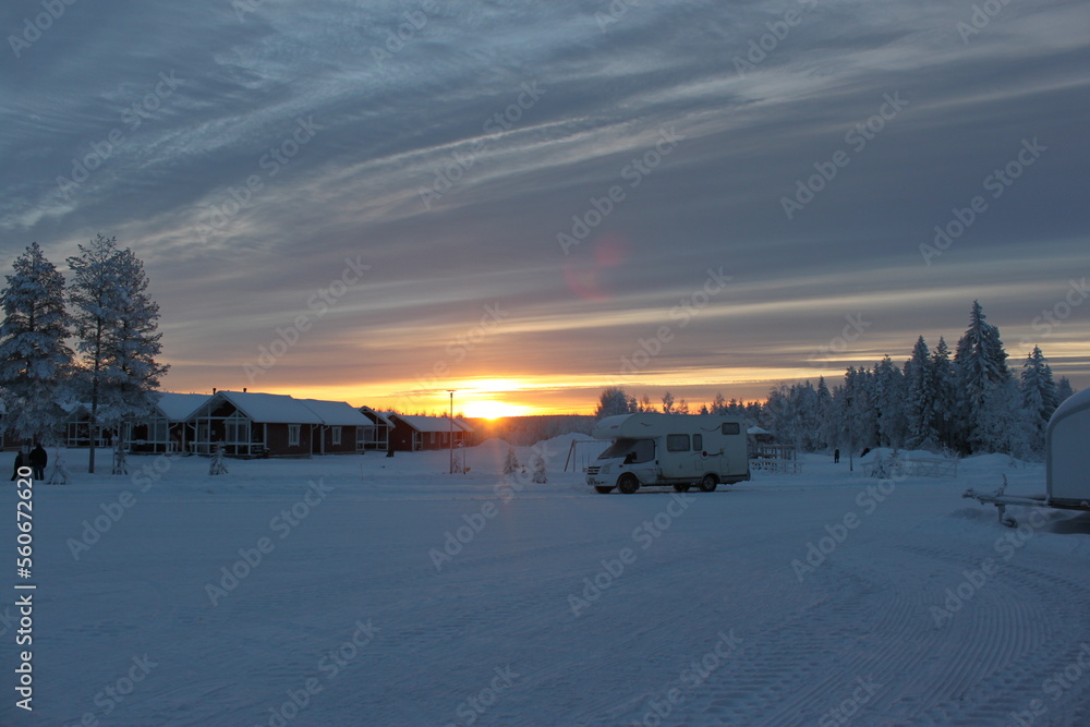 Wooden snow houses at beautiful orange sunset