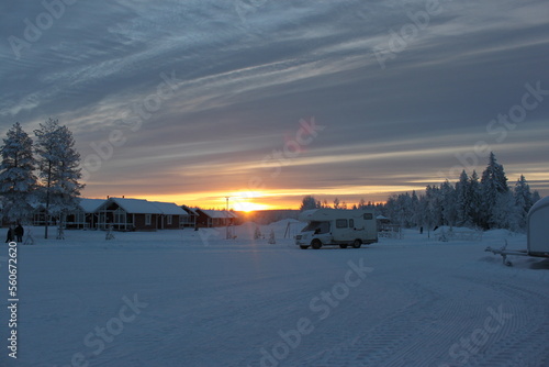 Wooden snow houses at beautiful orange sunset