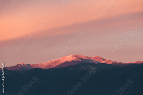 Obraz na płótnie Stunning sunset with beautiful shades of orange, pink, purple and blue colors with the silhouette of a mountain range. Wallpaper, natural background with copy space. w salonie