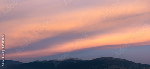 Stunning sunset with beautiful shades of orange  pink  purple and blue colors with the silhouette of a mountain range. Wallpaper  natural background with copy space.