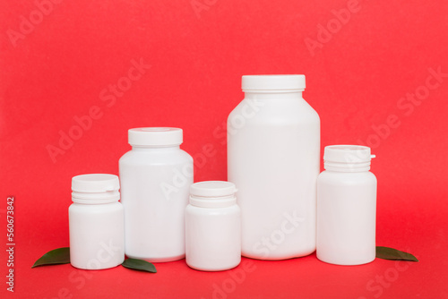 supplement pills with medicine bottle health care and medical top view. Vitamin tablets. Top view mockup bottle for pills and vitamins with green leaves, natural organic bio supplement, copy space