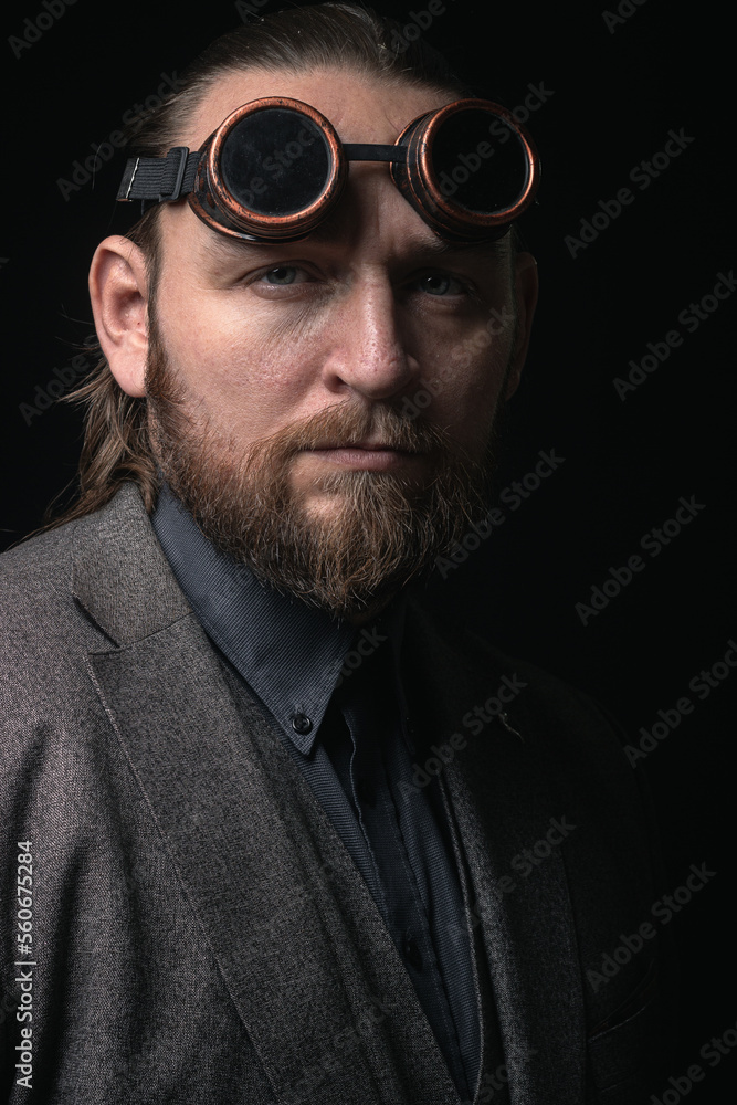 charismatic man in a classic suit and steampunk goggles on a black background stylish Portrait charismatic man in a classic suit and steampunk goggles on a black background stylish Portrait