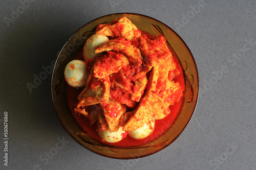 Tahu bali or balinese seasoned tofu is Indonesian food made from fried tofu and eggs prepared with spices: shallots, garlic, large red chilies, brown and white sugar, on black background, top view.