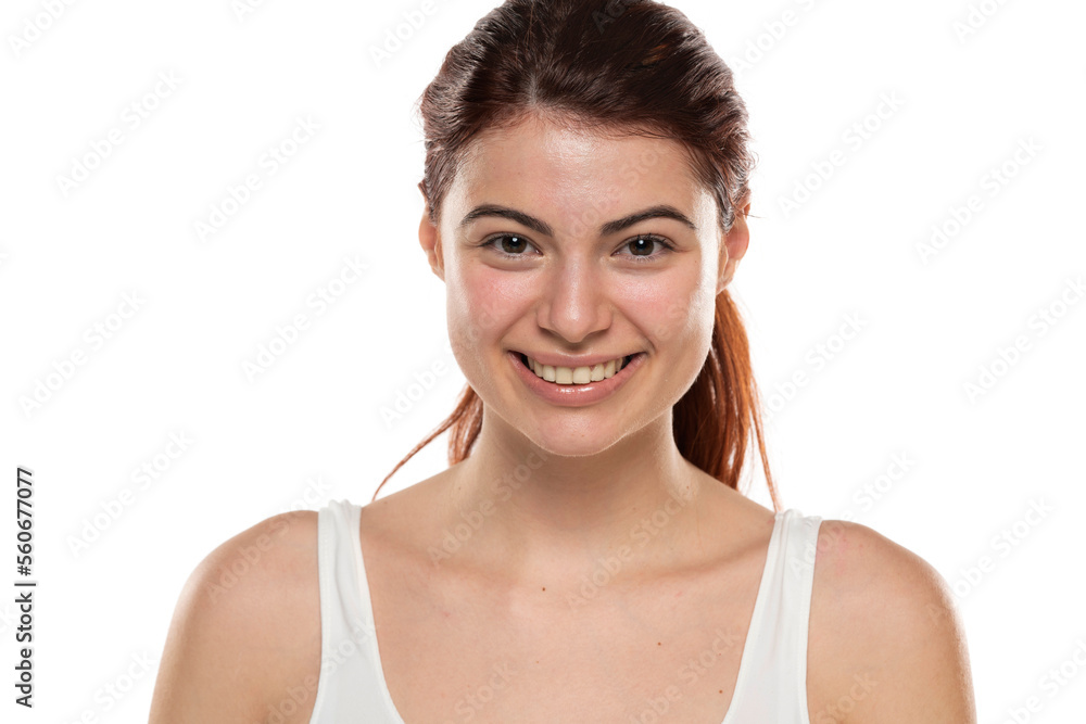 a young smiling redhead woman without makeup with long hair on a white background a young smiling redhead woman without makeup with long hair on a white background