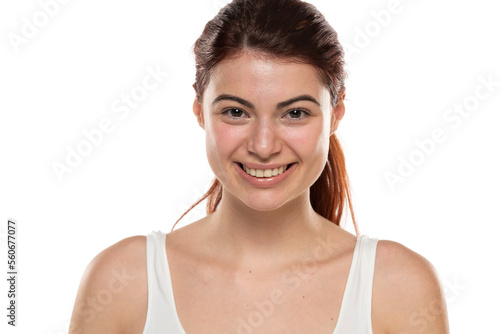 a young smiling redhead woman without makeup with long hair on a white background