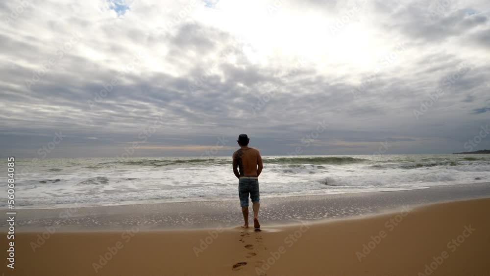 Lonely man enjoying the Sea and the empty beach in Winter time Lonely man enjoying the Sea and the empty beach in Winter time