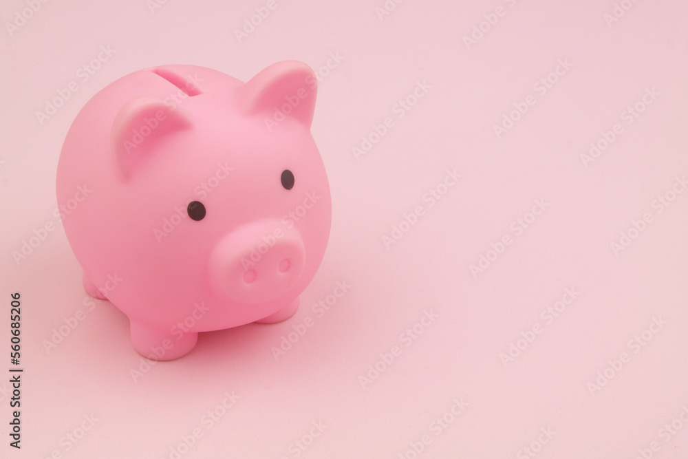 Pink piggy bank on pink background with copy space for text. Savings and investing concept.