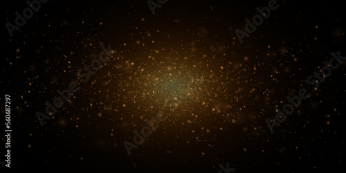 Christmas festive background of light confetti and small shining golden lights on a black background. Shiny golden texture.