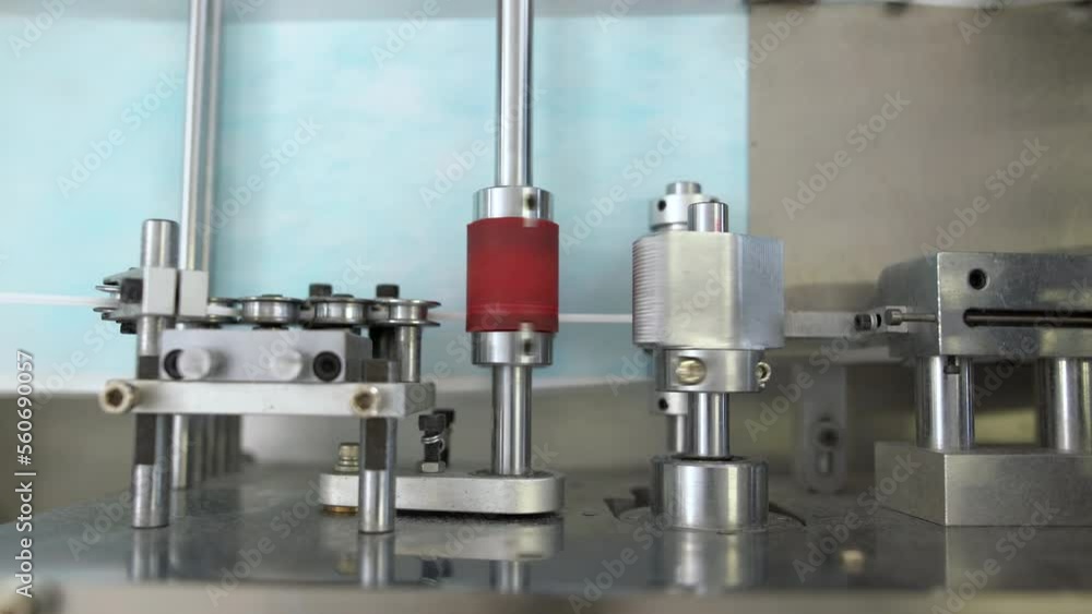 Closeup process of medical face masks being made in a factory. Automated machinery making respiratory medical masks in large quantities. Closeup process of medical face masks being made in a factory. Automated machinery making respiratory medical masks in large quantities.