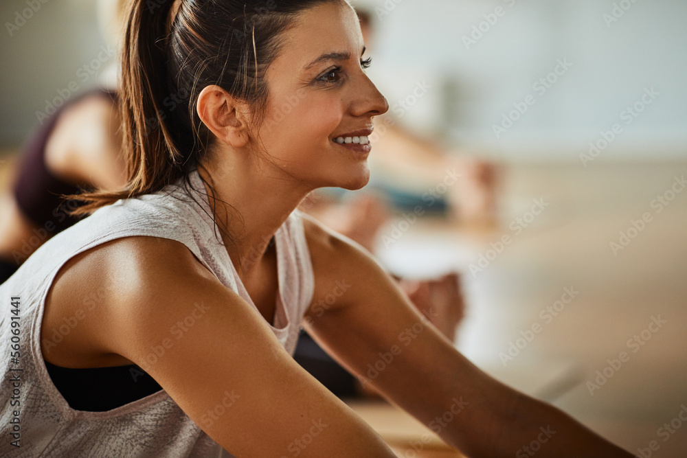 Smiling woman relaxing on a gym floor after yoga class