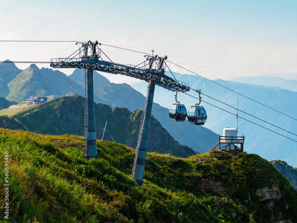 Krasnaya Polyana, Sochi, Russia - August 24, 2022: cable car in the mountains in summer. Cabins arrive at Rosa Peak Station