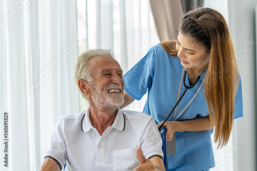 Man being cared for by a private Asian nurse at home suffering from Alzheimer's disease to closely care for elderly patients with copy space on left