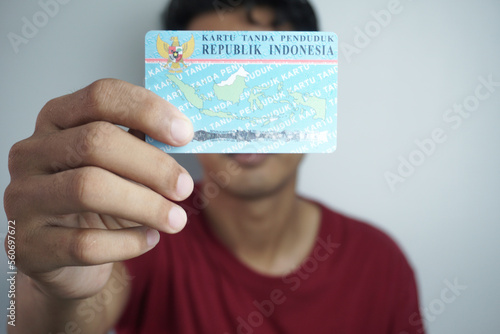 Jakarta, Indonesia - June 4, 2022: A person shows and holds two Indonesian identity cards (KTP). Selective focus photo