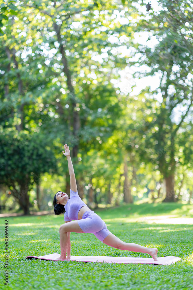 Attractive and strong Asian woman with a beautiful body. yoga in graceful posture in the green park Modern concept of relaxation and health care. Attractive and strong Asian woman with a beautiful body. yoga in graceful posture in the green park Modern concept of relaxation and health care.