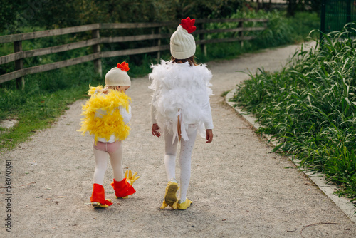 two kids walking in a chicken costume photo