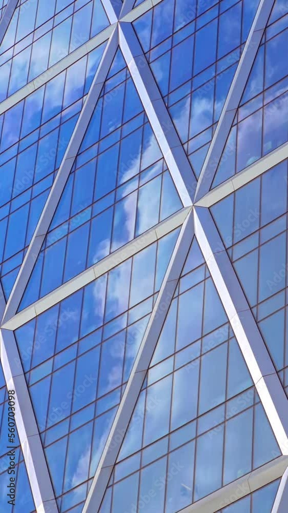 NYC skyscraper detail, sky reflection over glass façade, vertical background, time lapse NYC skyscraper detail, sky reflection over glass façade, vertical background, time lapse