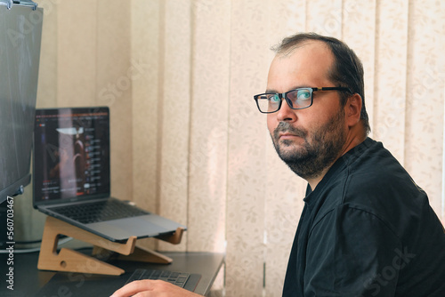 Φωτογραφία A European man in glasses works at a computer