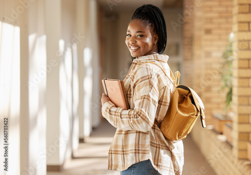 College student portrait, black woman and university with books and backpack while walking at campus. Young gen z female happy about education, learning and future after studying at school building