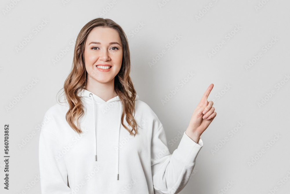 young woman pointing her finger up at copy space isolated on white background young woman pointing her finger up at copy space isolated on white background
