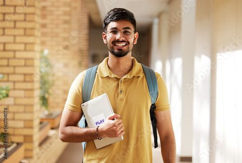 Face portrait, student and man in university ready for back to school learning, goals or targets. Scholarship, education and happy, confident and proud male from India holding tablet for studying. photo