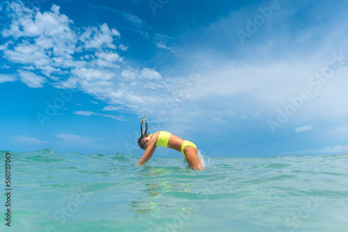 Girl diving into aqua blue water photo