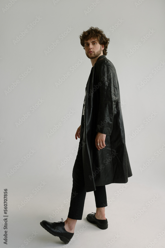 Attractive curly man in a black leather jacket and shoes Attractive curly man in a black leather jacket and shoes