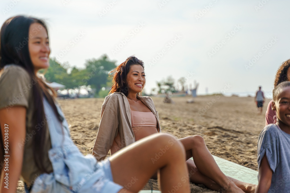 Smiling women sitting together at beach in summer Smiling women sitting together at beach in summer