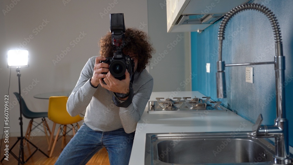 Photographer man taking pictures and video in apartment - real estate home photoshoot for selling house whit professional estate agency - home staging and enhance the property for advertising