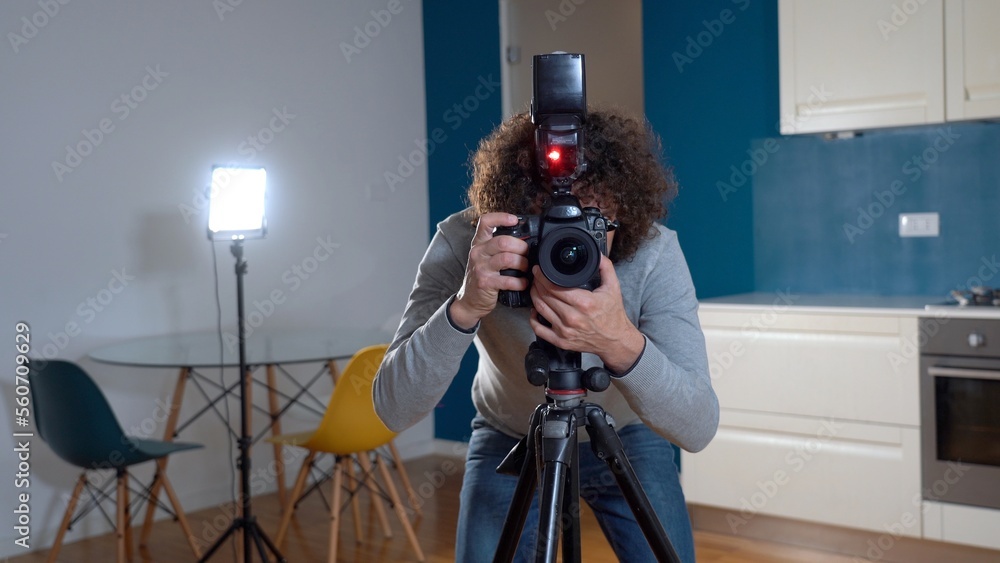 Photographer man taking pictures and video in apartment - real estate home photoshoot for selling house whit professional estate agency - home staging and enhance the property for advertising