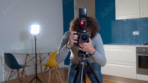 Obraz na płótnie Photographer man taking pictures and video in apartment - real estate home photoshoot for selling house whit professional estate agency - home staging and enhance the property for advertising w salonie