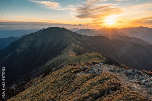 Mountain ridge under cloudy sky at sunset