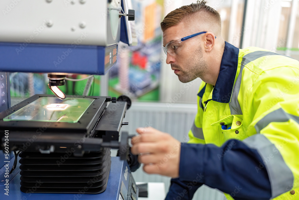 Engineer sitting in robot fabrication room use measuring microscope machine check microchip Engineer sitting in robot fabrication room use measuring microscope machine check microchip