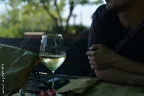 A man in a terrace with a white wine photo